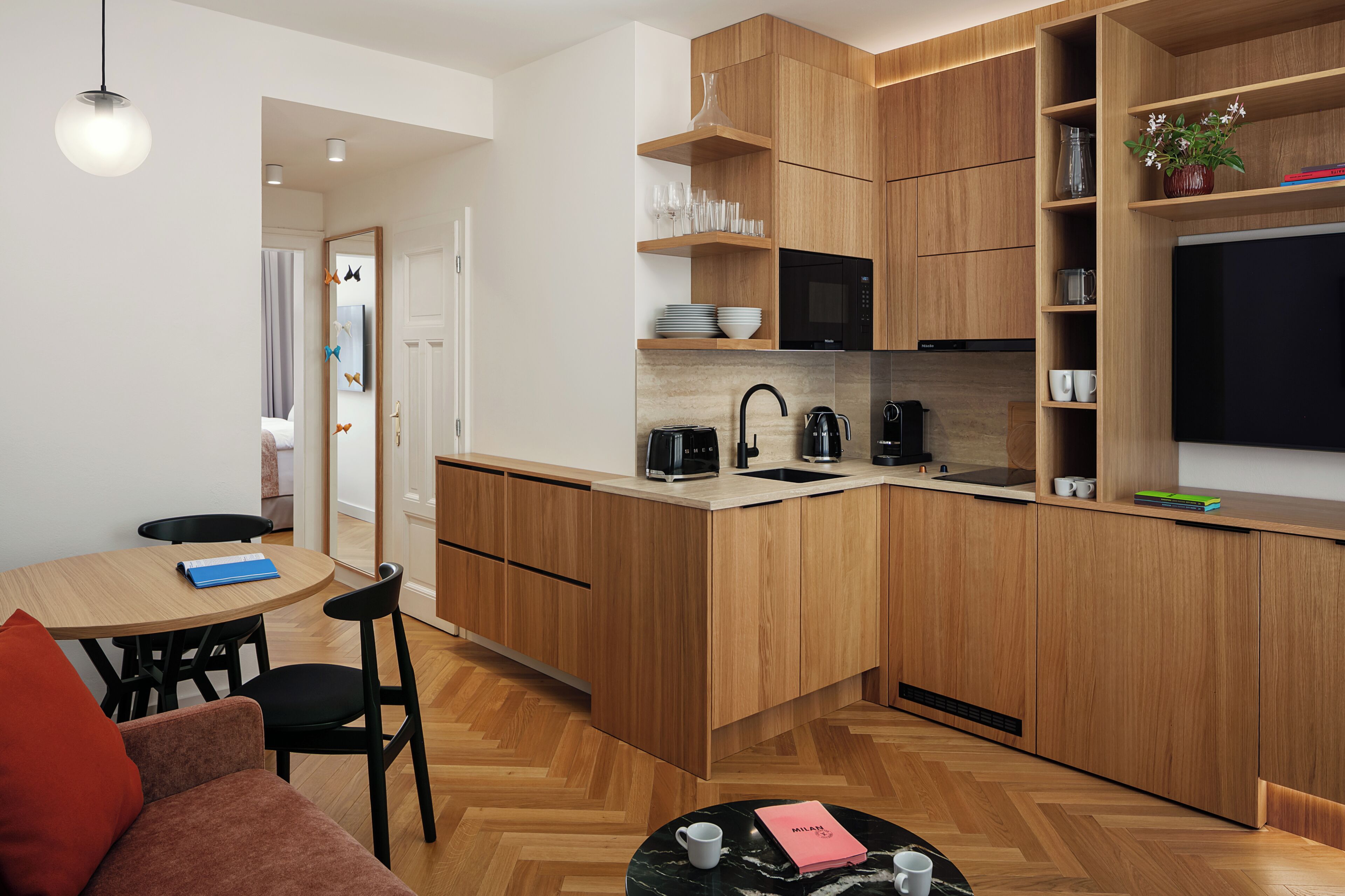 Una cocina moderna con armarios de madera, microondas integrado y cafetera.