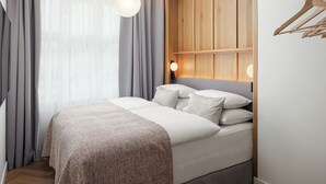 Un dormitorio moderno con cama, cortinas, una lámpara colgante y un panel de pared de madera.