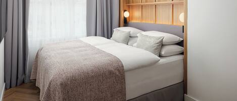 A modern bedroom with a bed, curtains, a hanging light fixture, and a wooden panel wall.