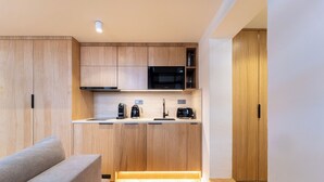 Una cocina moderna con armarios de madera, microondas, cafetera y tostadora.