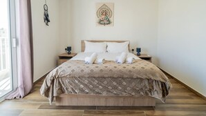 A neatly made bed with a patterned bedspread, two bedside tables with lamps, and a wall hanging above the bed.