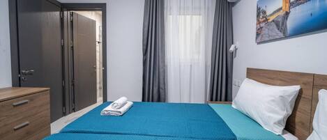 2 habitaciones, escritorio y tabla de planchar con plancha