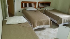 A hotel room with two single beds, a small bedside table, and a white cabinet. - Vieira's Palace Hotel (Paranaguá)