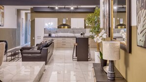 A modern living room with a leather sofa, a coffee table, and a large mirror. - Lovely 3BR maisonette, spacious w/Wifi, AC & Pool (Swieqi)