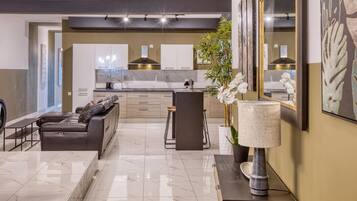 A modern living room with a leather sofa, a coffee table, and a large mirror.