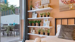 A bedroom with a bed, a window, and a view of an outdoor dining area. - Lovely 3BR maisonette, spacious w/Wifi, AC & Pool (Swieqi)