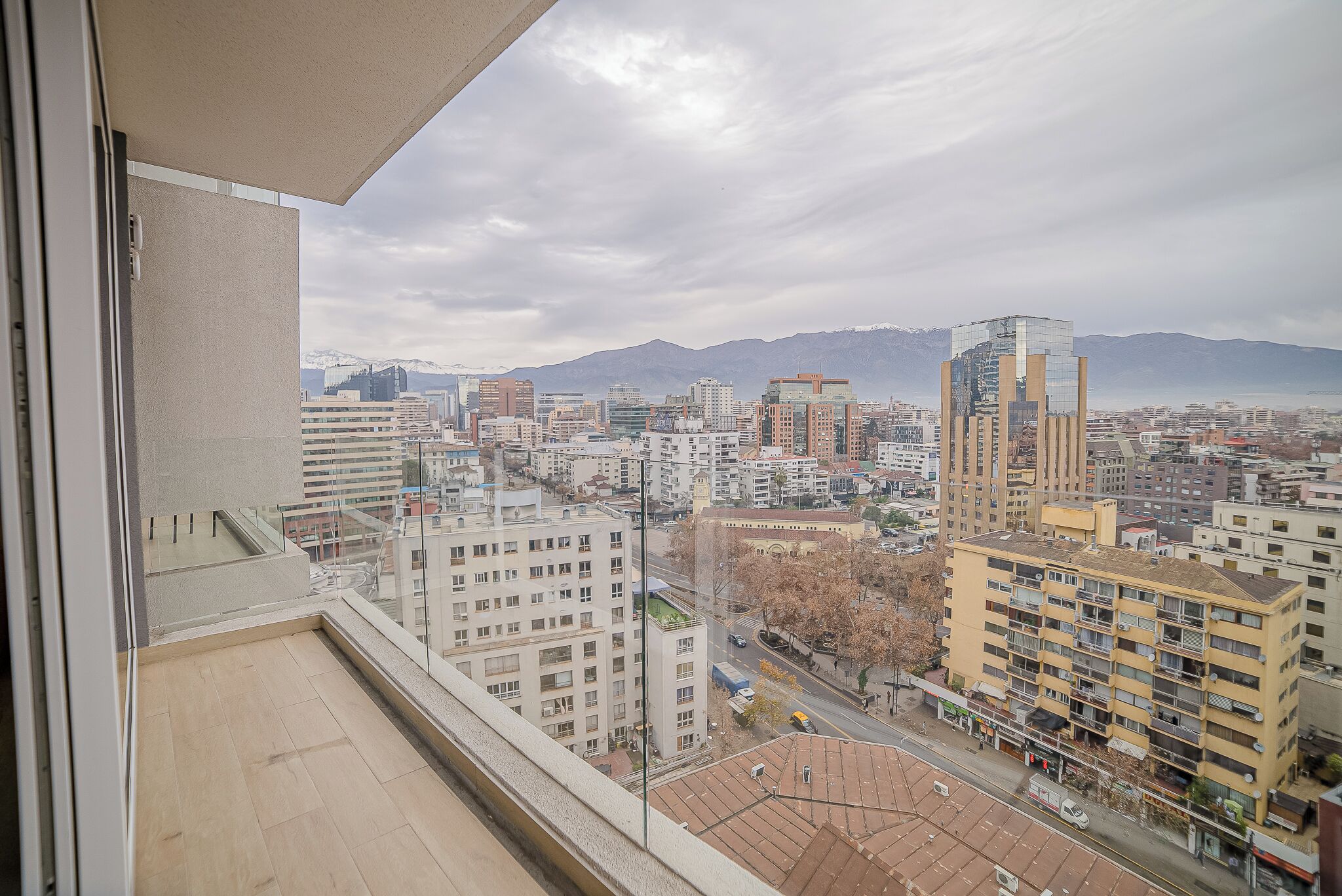 Un paisaje urbano con vistas a montañas distantes, edificios modernos y un cielo despejado.