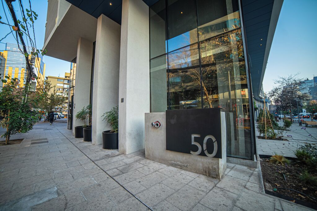 A modern building with a large glass facade, numbered '50', and a clean, urban street setting.