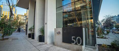 Un edificio moderno con un amplio frente de vidrio, numerado '50', y un entorno urbano limpio y ordenado.