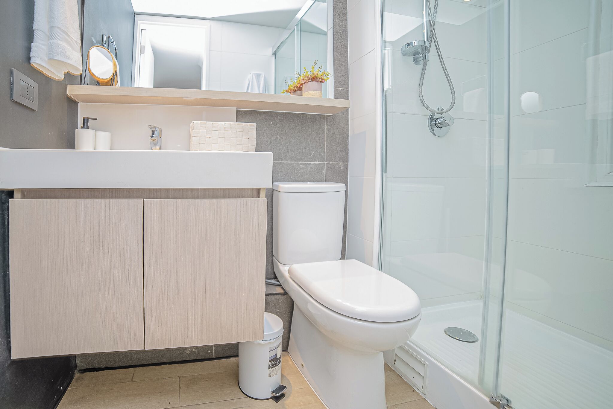 A modern bathroom with a toilet, sink, and shower.