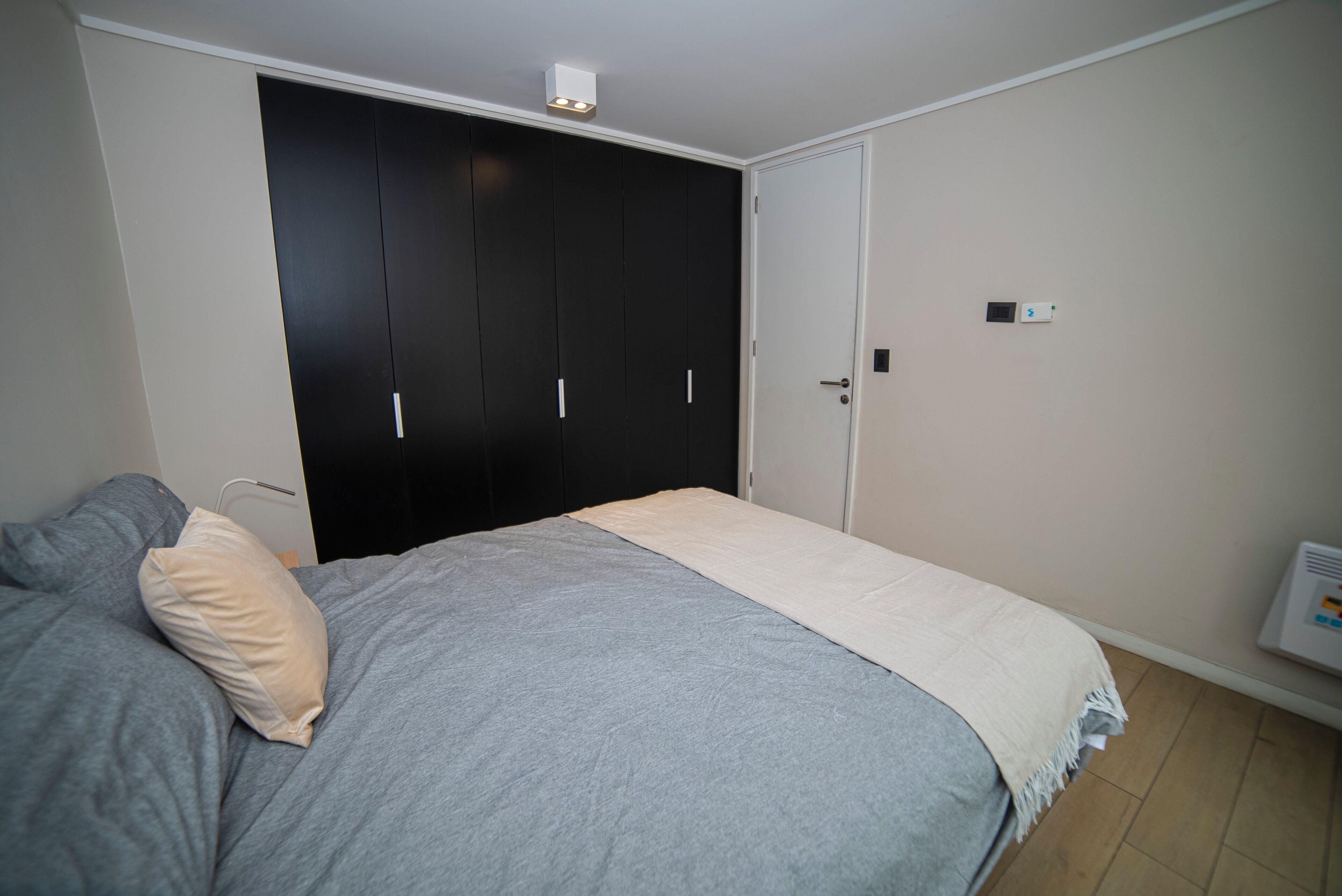 Une chambre à coucher avec un lit, une armoire et un radiateur.