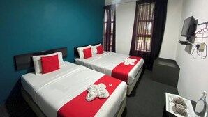 Une chambre d’hôtel avec deux lits, des murs de couleur turquoise et un téléviseur fixé au mur.