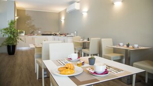 Uma área de jantar moderna com mesas, cadeiras e um espaço para café.