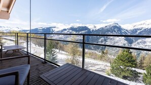 A balcony with a wooden floor and seating, overlooking a snowy mountain landscape. - Chalet, 100m from ski slopes, Ground floor, view mountain, sauna, terrace, balcony (La Plagne)