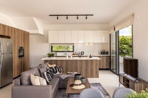Una cocina moderna con una isla central, horno empotrado y refrigerador.