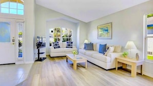 A modern living room with a sofa set, a coffee table, and a side table with a lamp.