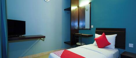 A hotel room with a bed, a TV, a desk, and a chair.
