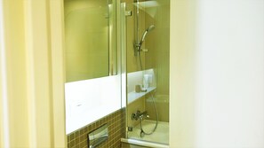 A bathroom with a glass shower enclosure, a white sink, and a towel rack. - Spacious & Elegant Apartments in Southbank near London Eye (London)