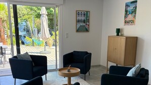 A modern living room with dark blue armchairs, a wooden coffee table, and a cabinet. - Family villa with a pool, 100 meters from the beach – Le Lavandou (Le Lavandou)