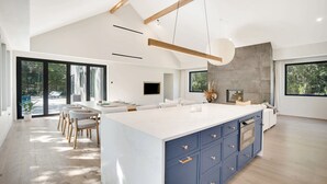 Un'ampia cucina con una grande isola, elettrodomestici moderni e molta luce naturale.