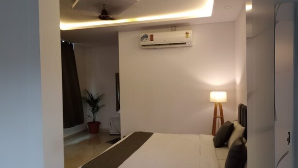 Ein modernes Schlafzimmer mit einem Marmor-Bett, einer Stehlampe und einer Klimaanlage an der Wand.