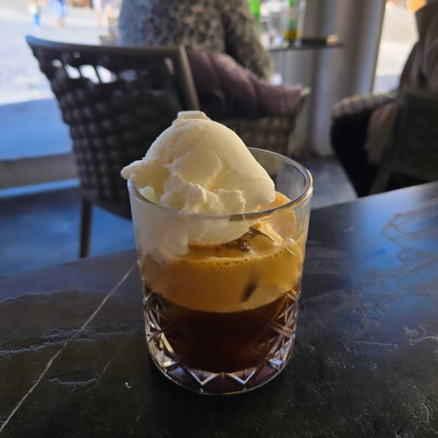 Un verre de café glacé surmonté d’une boule de glace à la vanille.