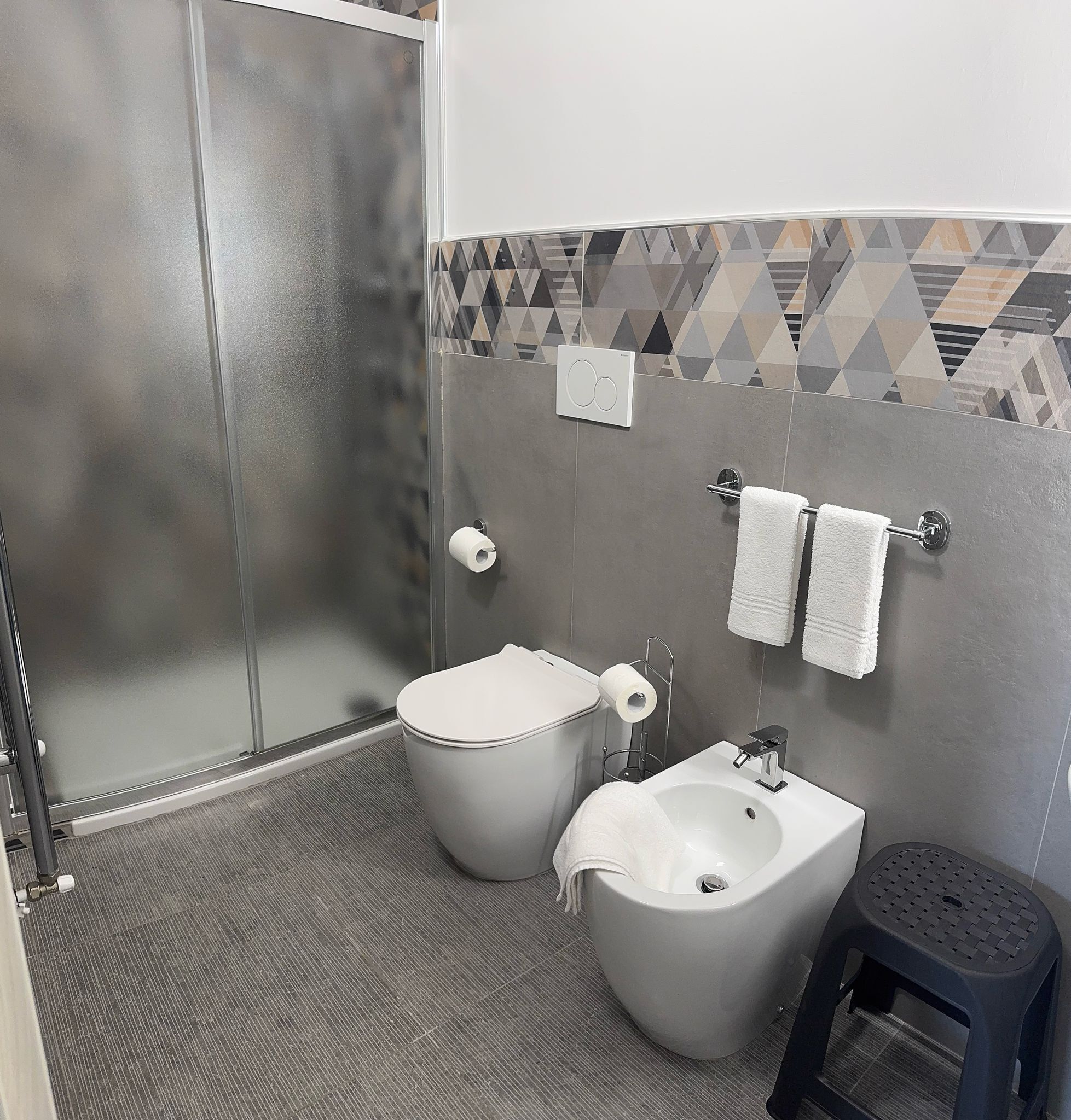 Une salle de bain équipée de toilettes, d’un bidet et d’une douche.