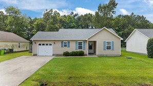 A single-story house with a garage, a front porch, and a well-maintained lawn. - 3-Bedroom Retreat with King Suite, Pool Table & Private Fenced Yard (New Bern)