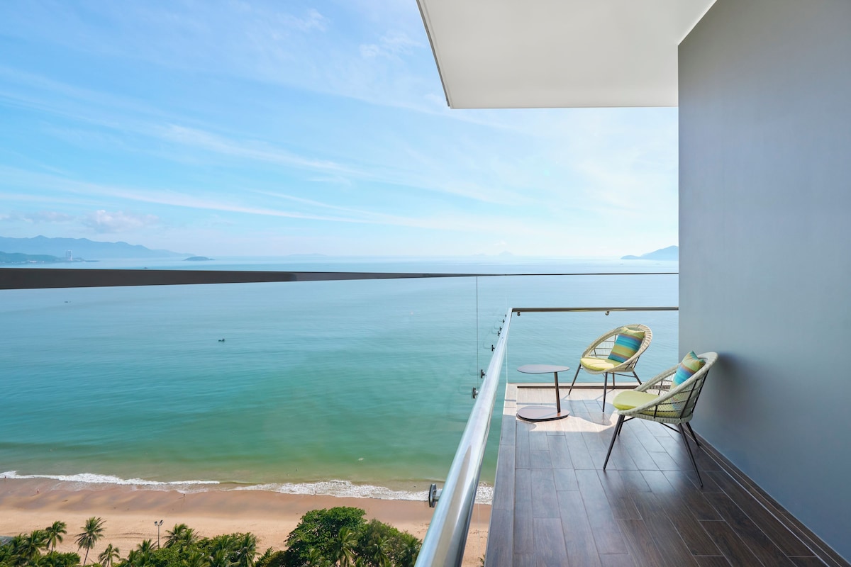 A balcony with a view of the ocean and beach.