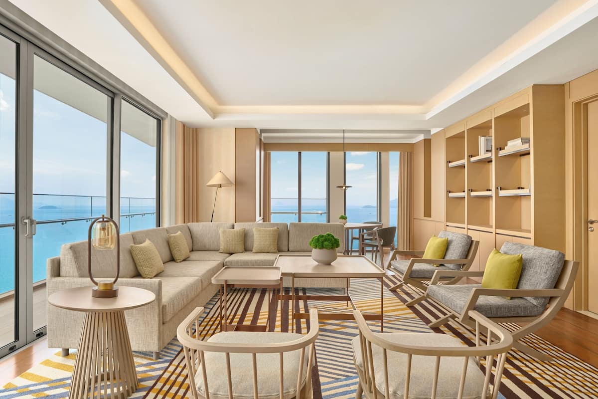A modern living room with a sofa, chairs, a coffee table, and a bookshelf.