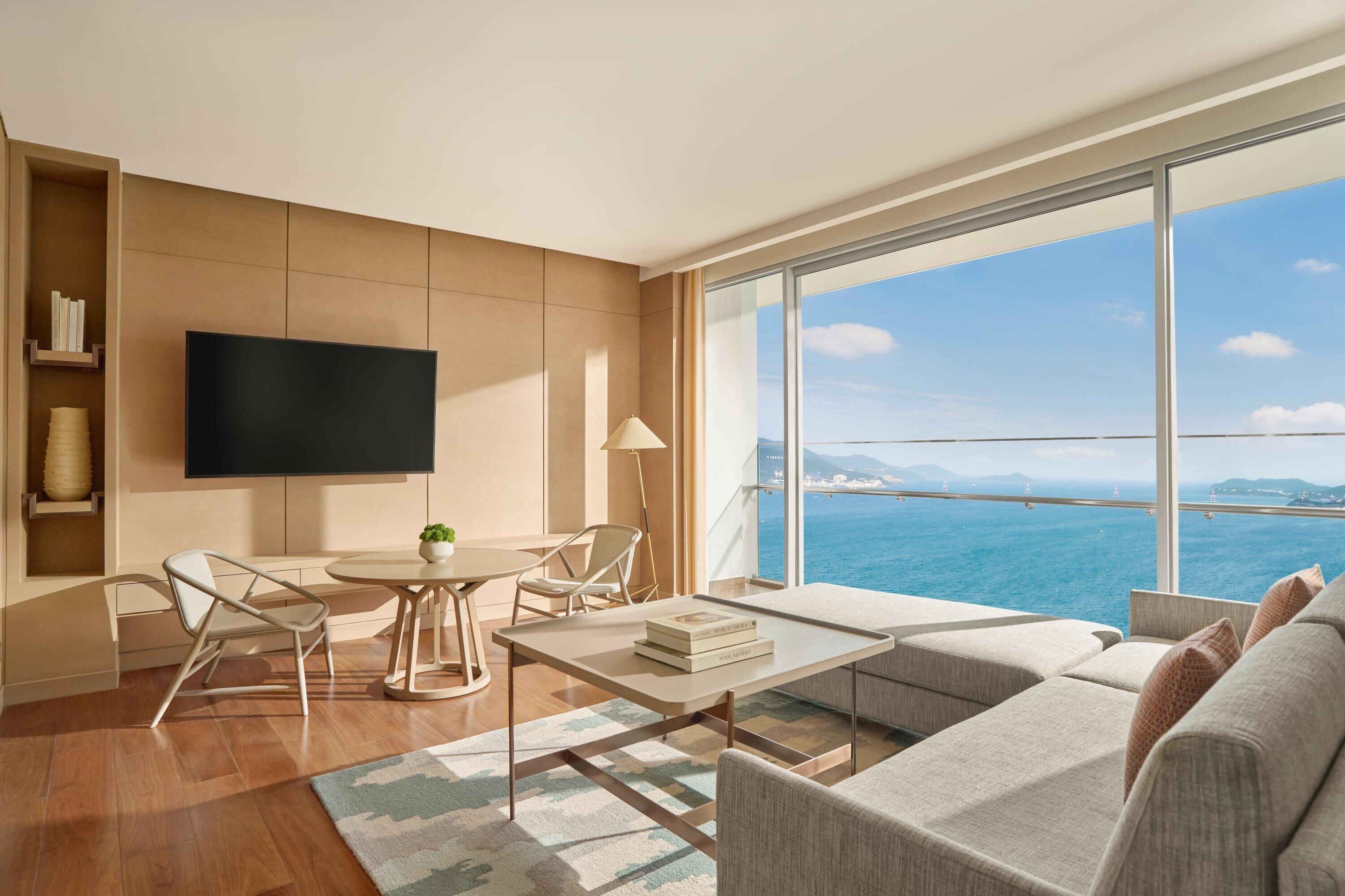 A modern living room with a large TV, a dining table, and a sofa.