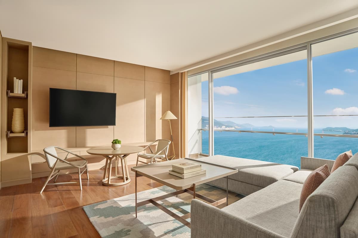A modern living room with a large TV, a dining table, and a sofa.