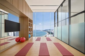 A modern room with a large window, exercise mats, and a TV on the wall. - Hyatt Regency Nha Trang (Nha Trang)