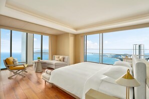 Une chambre d’hôtel spacieuse, dotée d’un grand lit, d’un canapé, d’un fauteuil et d’une petite table.