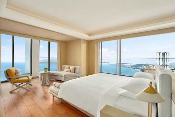 A spacious hotel room with a large bed, a sofa, a chair, and a small table. - Hyatt Regency Nha Trang (Nha Trang)