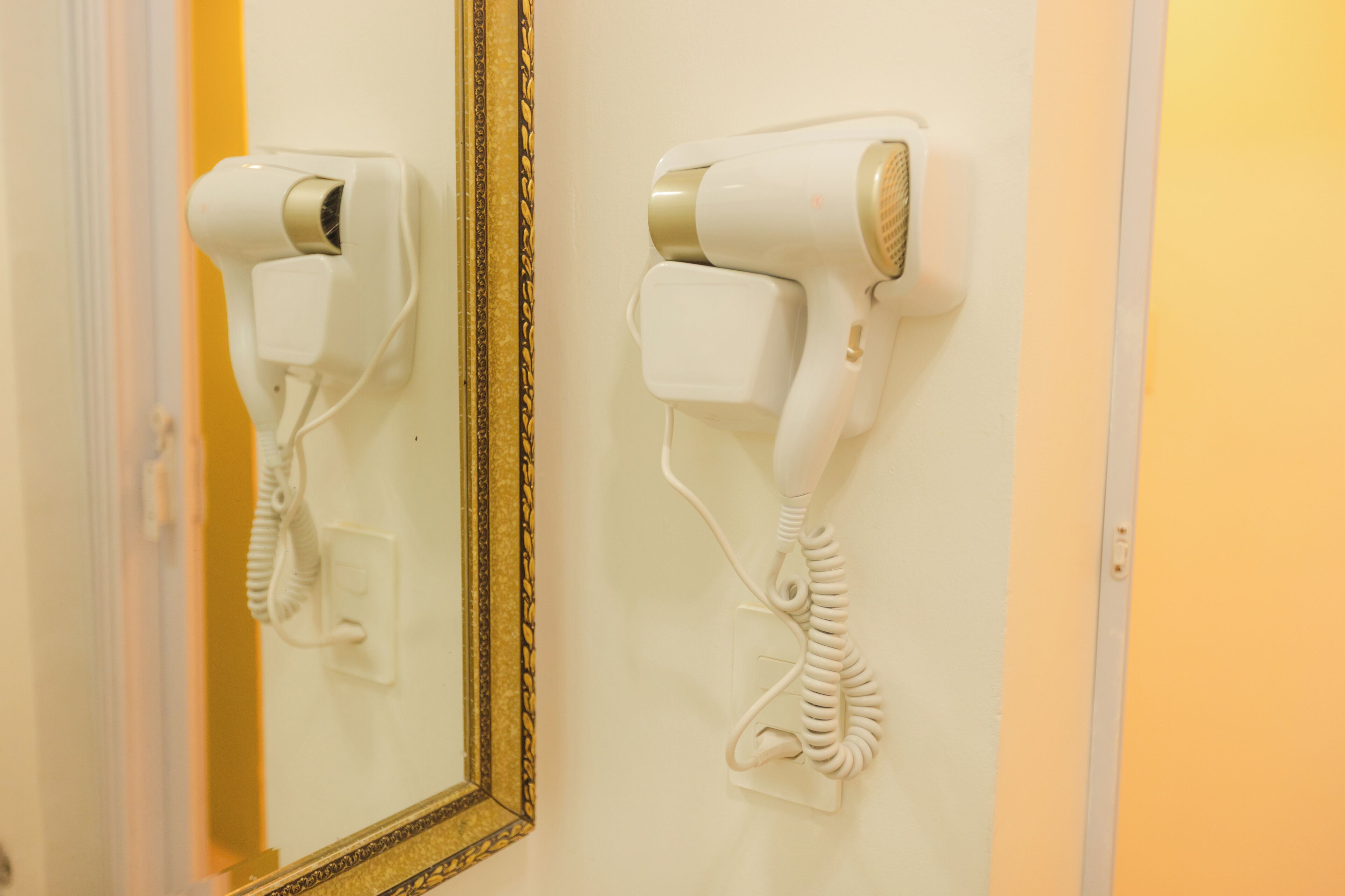 Un secador de pelo y teléfono montados en la pared de una habitación de hotel.