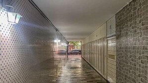 A corridor with patterned walls, a tiled floor, and a metal gate at the end. - 360 Flamengo Marques de Abrantes By SUHCasa (Rio de Janeiro)