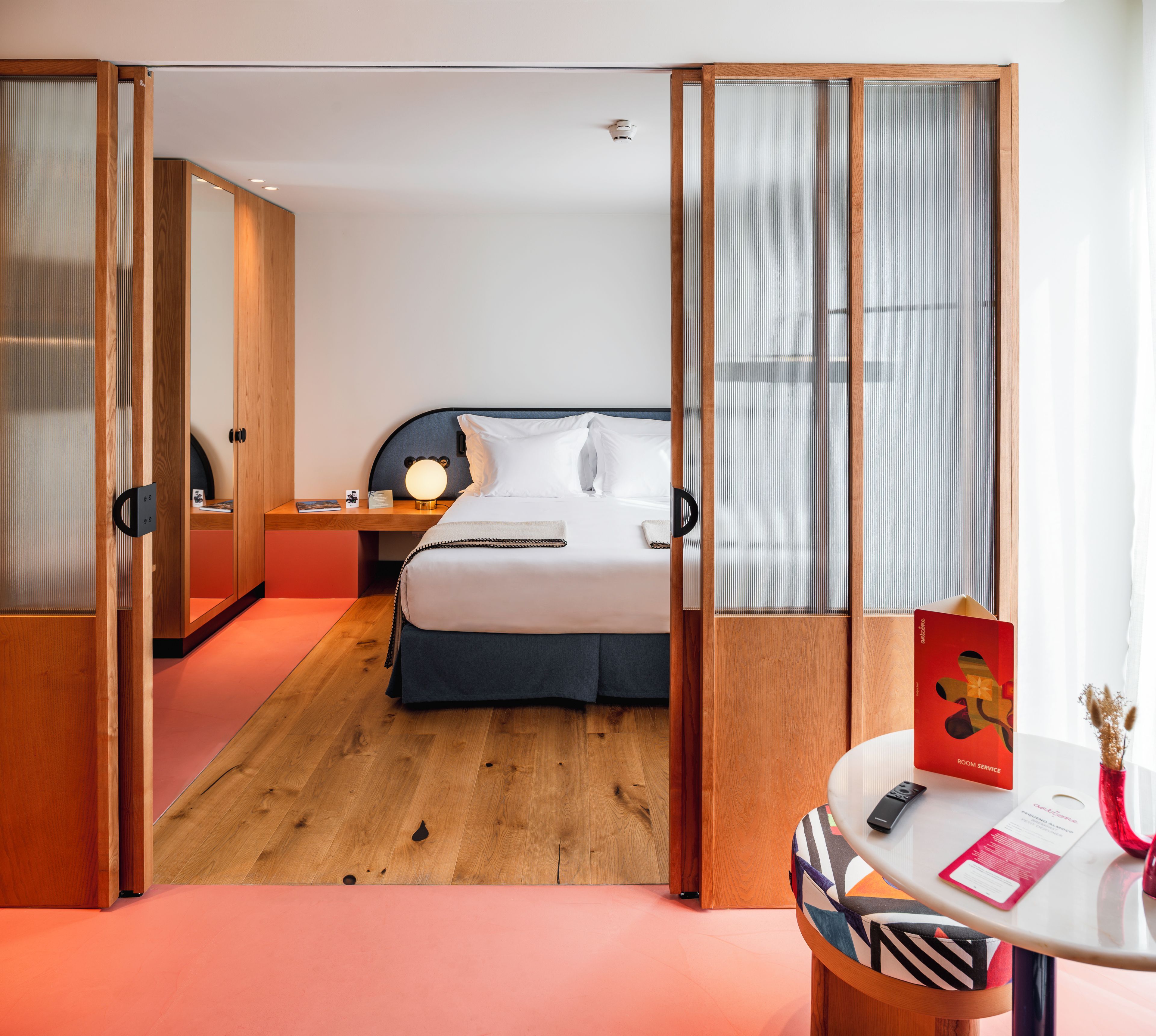 Una habitación de hotel con cama, mesita de noche y escritorio con silla.
