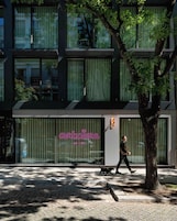 Un edificio moderno con escaparate que presenta un letrero de neón que dice 'artcore ART IS ALL'.
