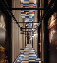Un corridoio con pareti e pavimento decorati, e un soffitto con motivo geometrico.