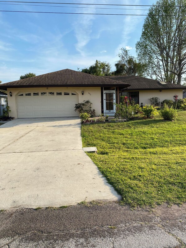 A single-story house with a garage, a front lawn, and a driveway. - The Palms at Poinciana: Private Tropical Resort (Kissimmee)