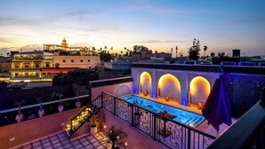 A rooftop pool area with a pool, seating, and a view of the cityscape at dusk. -  Riad Hamdane Rooftop & SPA  (Marrakech)