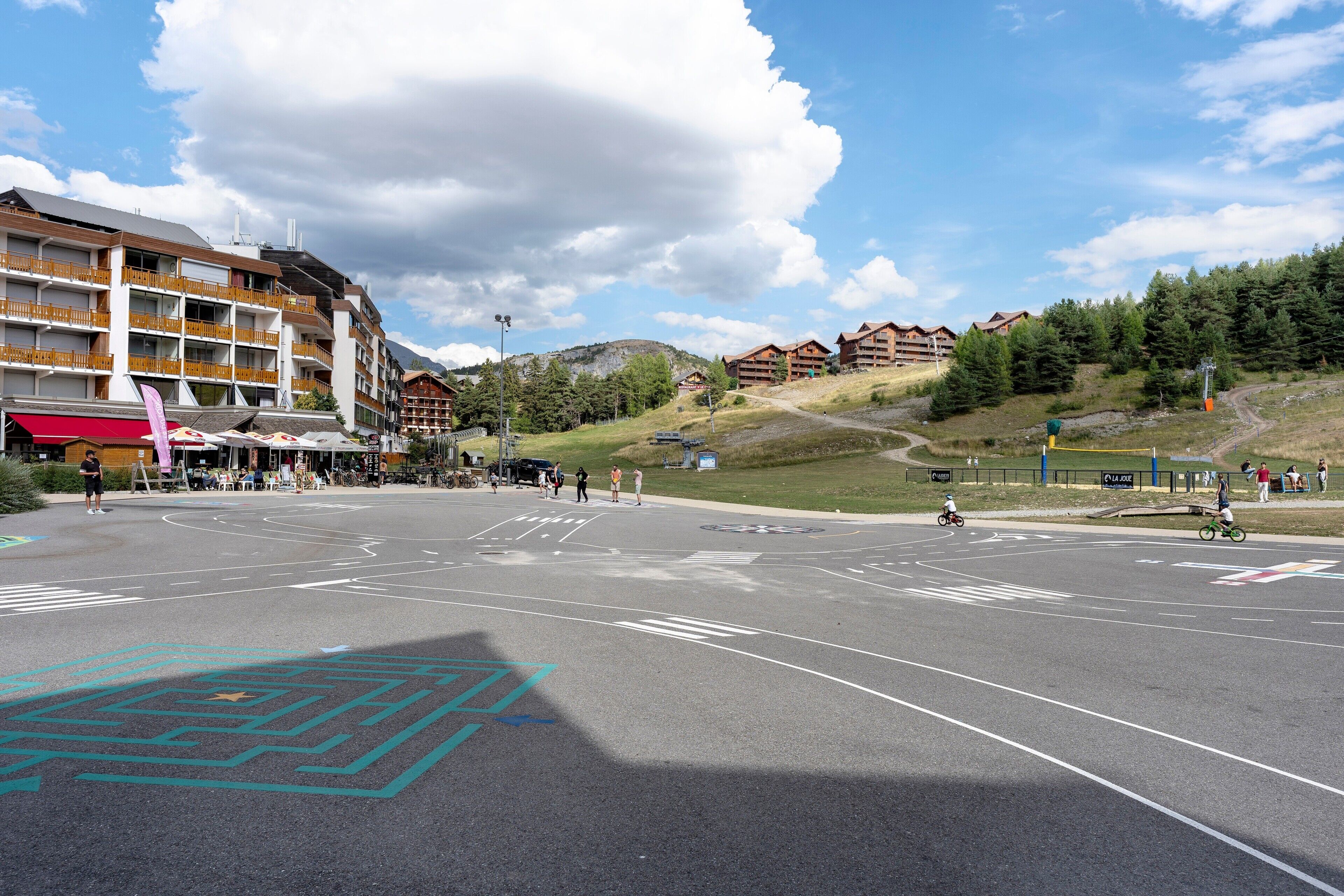 A ski resort with multi-story buildings, a ski lift, and a clear sky.