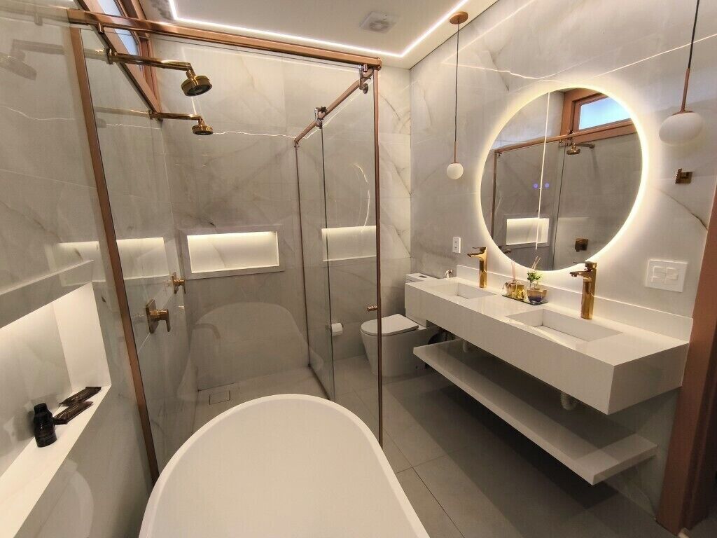 A modern bathroom with a glass-enclosed shower, a freestanding bathtub, and a vanity with a large mirror.