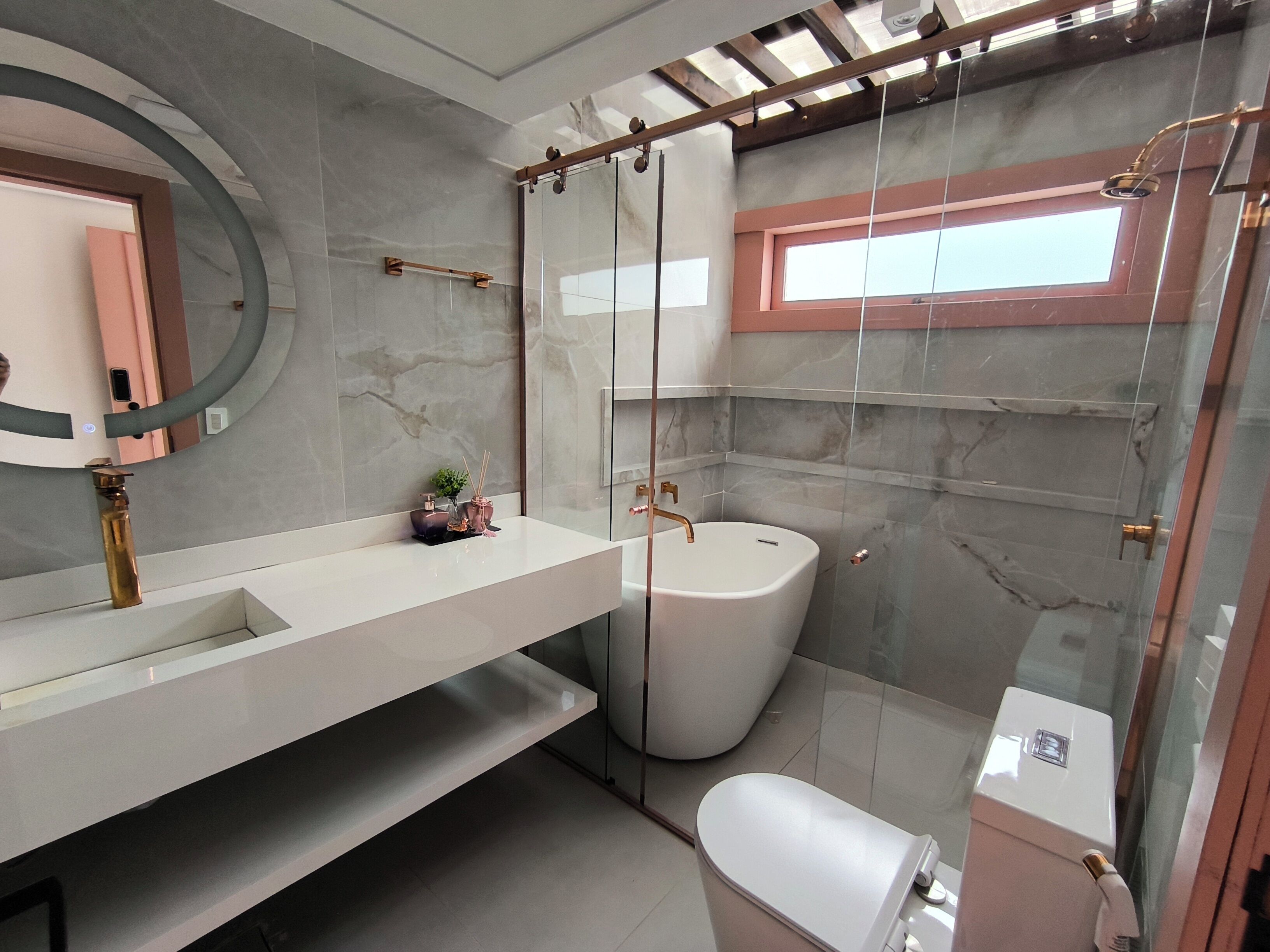 Une salle de bain moderne avec une douche à parois de verre, un lavabo blanc et des toilettes.