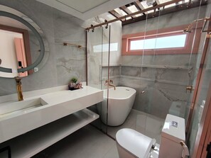 Ein modernes Badezimmer mit Duschkabine aus Glas, einem weißen Waschbecken und einer Toilette.