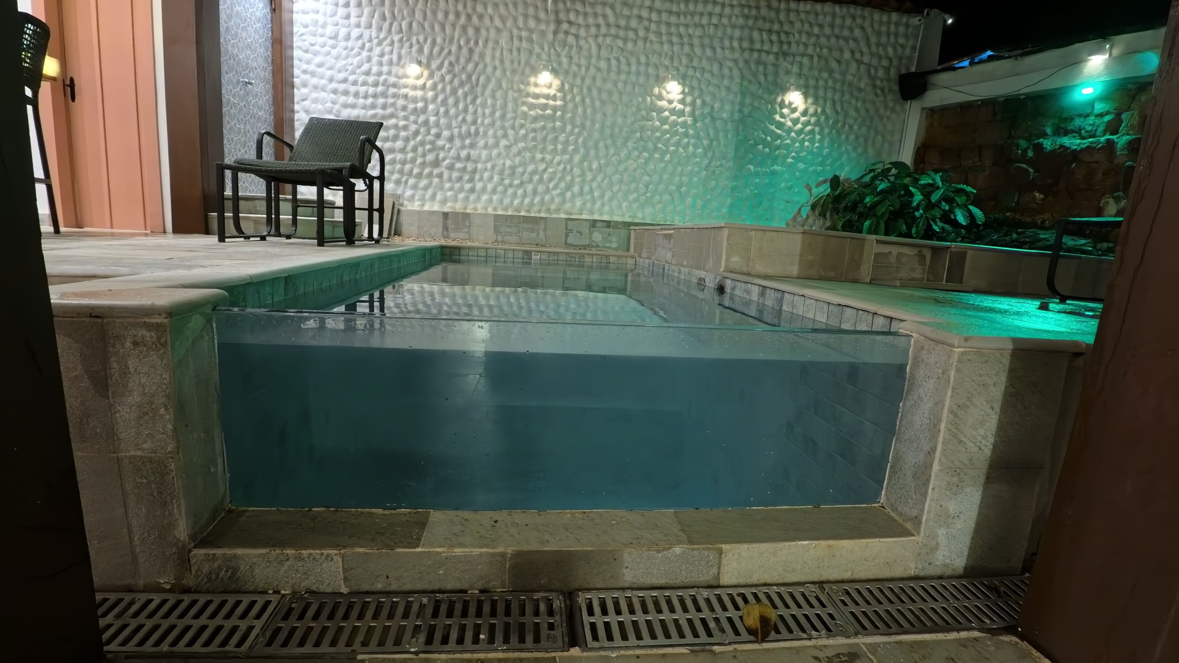 A swimming pool with stone steps and a chair.