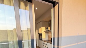 A modern kitchen with white cabinets, a black countertop, and a small island. - APARTMENT FREE SHUTTLE (Catania)