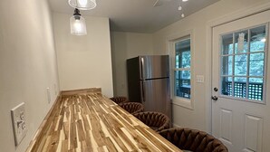 Una cocina con encimera de madera, un refrigerador y un ventilador de techo.