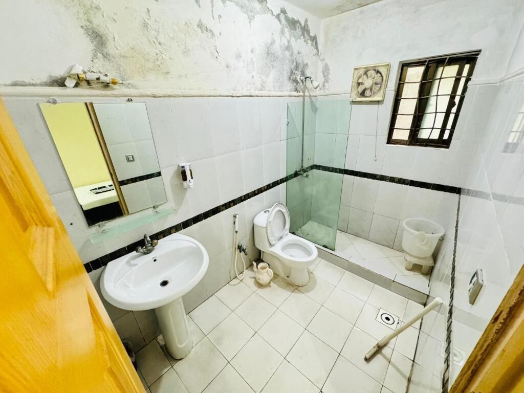 Un bagno con lavandino, WC e cabina doccia in vetro.